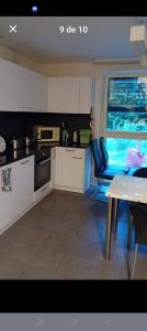 a kitchen with white cabinets and a table and a window at Home luna &zeus in Lausanne +7 photos