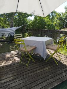 a table and two chairs and an umbrella on a deck at Iglesias Emmanuelle in Pradines +8 photos