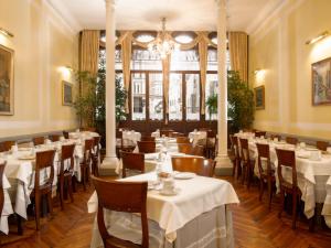 un restaurante con mesas y sillas y una lámpara de araña en Centauro Hotel, en Venecia