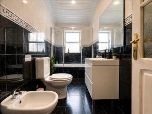 a black and white bathroom with a toilet and a sink at Botânico Guesthouse in Nordeste