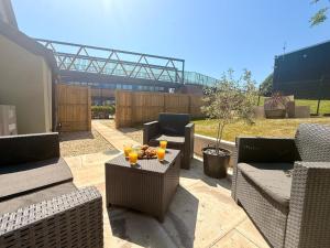 a patio with two chairs and a table with drinks on it at Unique Devon Cottages - Sunrise Cottage in Exmouth