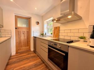a kitchen with a sink and a stove at Unique Devon Cottages - Sunrise Cottage in Exmouth