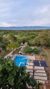 an overhead view of two swimming pools in a field at 4Rest Villa in Novalja
