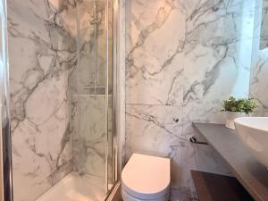 a bathroom with a shower and a toilet and a sink at Unique Devon Cottages - Sunrise Cottage in Exmouth +9 photos
