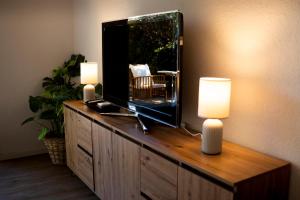 a television on a wooden dresser with two candles at Anna's Landhaus in Soltau