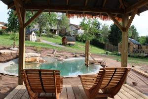 a patio with two chairs and a swimming pool at Tiny House chez Lili in Frémifontaine