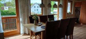 a dining room with a table and chairs and windows at Ferienhaus Keim in Negenborn