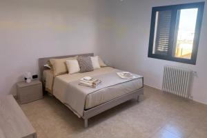 a bedroom with a bed with a table and a window at La Dimora di Valesio in Torchiarolo +6 photos