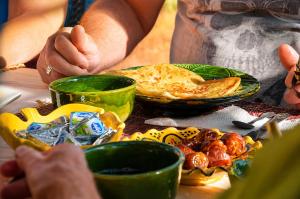 a person sitting at a table with a plate of food at Kasbah Abdou in El Kelaa des Mgouna