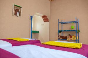 two beds sitting next to each other in a room at Kasbah Abdou in El Kelaa des Mgouna