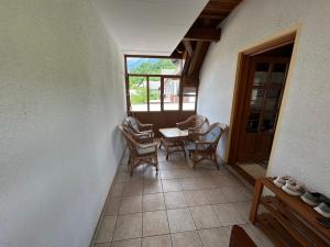 a porch with chairs and a table and a window at MMMM in Bovec
