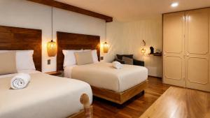 a hotel room with two beds and a chair at Terraza & Loft San Ángel in Mexico City