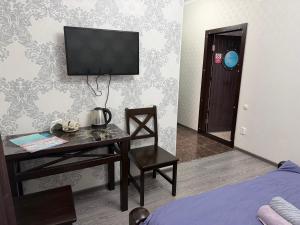 a room with a desk and a television on a wall at Посейдон ЖМ Амангельды ул Тепличная 4 in Kostanay +8 photos