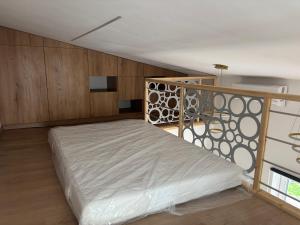 a bed in a room with wooden walls and a balcony at Apartament Ana in Lublin