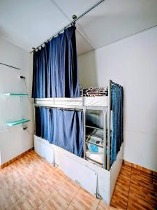 a room with a bed with a blue curtain at Orange3 Hostel in Lagos