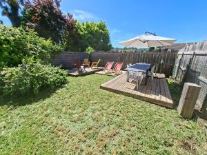a backyard with a deck with an umbrella and chairs at havre de paix in Saint-Junien