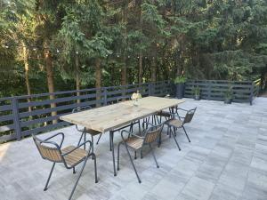 a wooden table and chairs on a patio at Forest Magic in Duga Resa