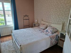 a bedroom with a bed and a window at havre de paix in Saint-Junien