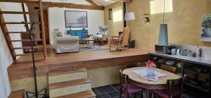 a living room with a table and a kitchen at Le Peyroutet in Cazaux-Villecomtal