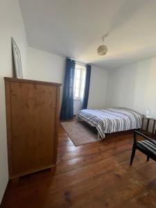 a bedroom with a bed and a wooden floor at BOISSET, Grande maison familiale avec vue sur les Pyrénées in Castel-Sarrazin
