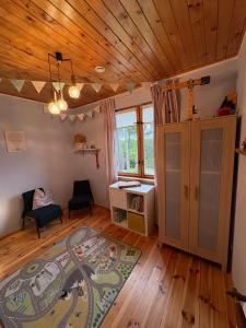 a living room with a wooden ceiling and a desk at Amaleczka Woda Las in Podjazdy