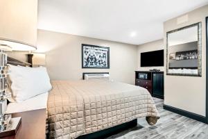 a hotel room with a bed and a flat screen tv at Best Way Inn in Middlefield