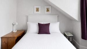 a bedroom with a white bed with a purple pillow at Bute Seaview in Rothesay