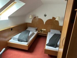 two beds in a small room with a window at Hotel Restaurant Ampertal in Haag an der Amper
