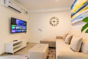 a living room with a couch and a clock on the wall at Hin Nan Hua Hin RELAX in Hua Hin