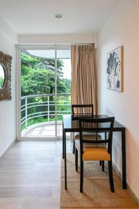a dining room with a table and chairs and a window at Hin Nan Hua Hin RELAX in Hua Hin