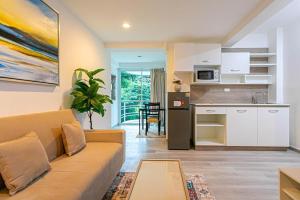 a living room with a couch and a kitchen at Hin Nan Hua Hin RELAX in Hua Hin