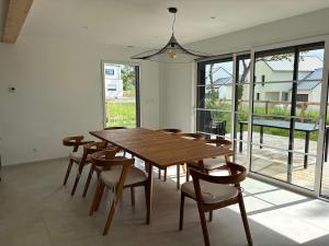 a dining room with a wooden table and chairs at Maison en bois moderne in Pléneuf-Val-André