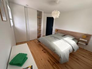 a bedroom with a large bed and a table at Maison en bois moderne in Pléneuf-Val-André