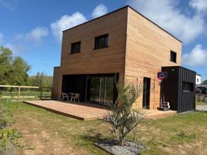 a large wooden house with a table in front of it at Maison en bois moderne in Pléneuf-Val-André