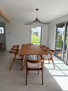 a dining room with a wooden table and chairs at Maison en bois moderne in Pléneuf-Val-André