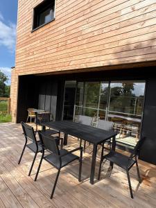 a black table and chairs on a wooden deck at Maison en bois moderne in Pléneuf-Val-André +3 photos