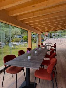a large table and chairs in a room with windows at Agritur Girardelli in Riva del Garda