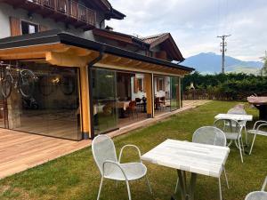 a patio with tables and chairs and a house at Agritur Girardelli in Riva del Garda