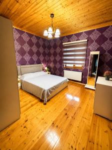 a bedroom with a bed and a purple wall at Green dream House in Lankaran