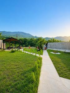 a path through a park with a grass field at Green dream House in Lankaran