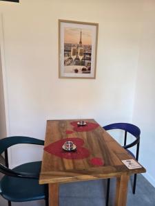 Ein Holztisch mit zwei Stühlen und ein Bild an der Wand in der Unterkunft L' Ecrin in Auch