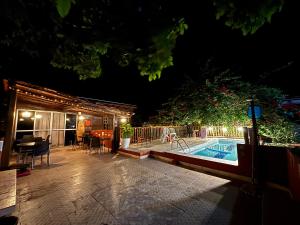 a backyard with a swimming pool at night at Pousada Vôo da Águia in Itacaré