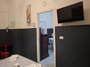 a room with a bed and a flat screen tv on the wall at Palazzo Ruisi in Scordia