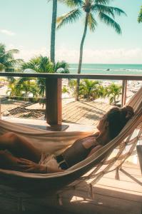 a woman laying in a hammock on the beach at Le Terrace in Morro de São Paulo