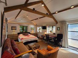 a bedroom with a bed and a desk in a room at Spacious Studio - Bicester Village & Silverstone in Middleton Stoney