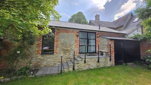 a brick house with a door and a gate at Spacious Studio - Bicester Village & Silverstone in Middleton Stoney