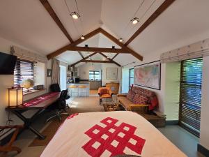 a bedroom with a bed and a living room at Spacious Studio - Bicester Village & Silverstone in Middleton Stoney