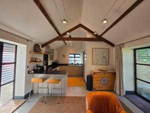 a kitchen with a counter and chairs in a room at Spacious Studio - Bicester Village & Silverstone in Middleton Stoney