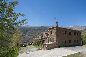 an old stone building with a cross on top of it at Alojamiento Rural El Balcón del Cielo in Trevélez