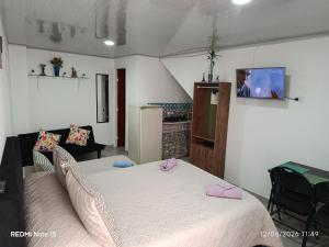 a bedroom with a bed and a tv on the wall at Mi Rincón Feliz in Choachí